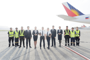 Philippine Airlines flight and ground crew standing beside a PAL aircraft on the tarmac, symbolizing the airline’s recognition as Asia-Pacific’s most punctual carrier in 2025